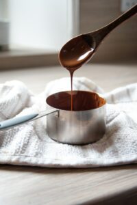 stainless steel cup with black liquid, melted chocolate