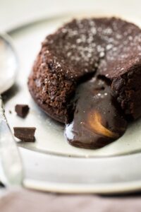 round baked chocolate cake on plate with molten center