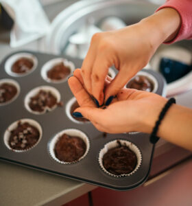 A cook decorating tasty muffins with chocolate crumbs