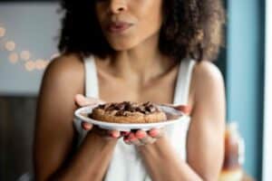 woman holding white ceramic plate with cookies