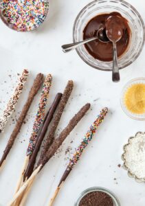 chocolate dipped bread sticks next to a bowl of melted chocolate