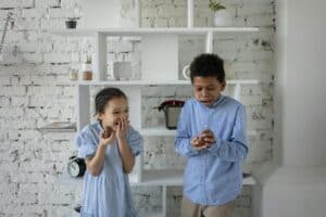 Siblings Laughing while Eating Chocolate Eggs